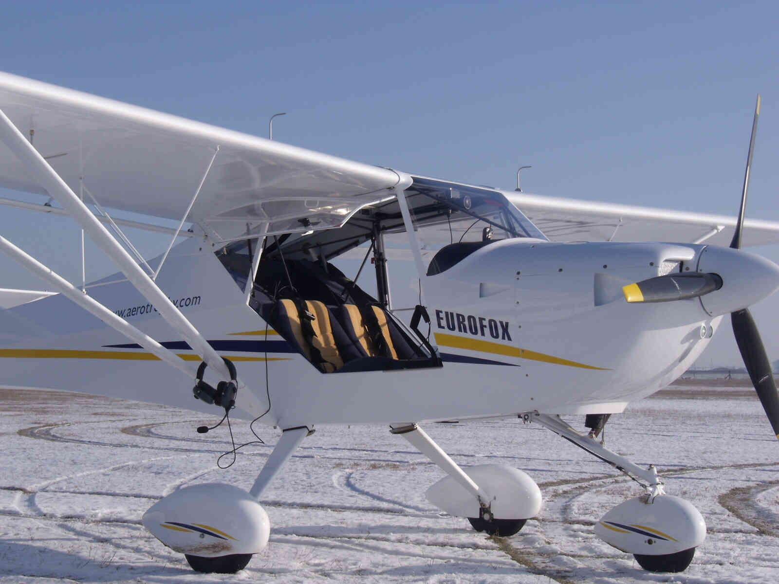 Avion ULM à l'arrêt sur un sol enneigé.